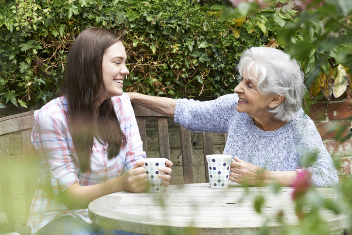 Young woman having coffee with a senior woman